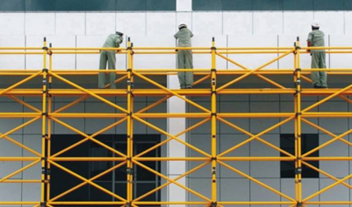 Three workers are standing on the FRP/GRP scaffolding for construction.
